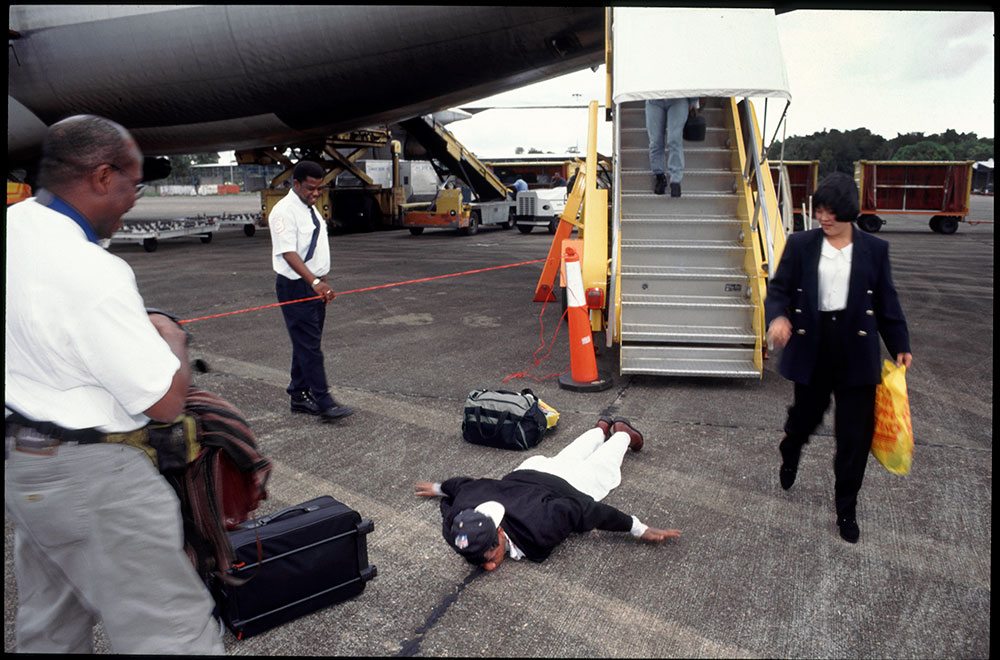 1996 - WINTI SURINAME - KLINIEK SANTIGRON - Guno komt aan op Zanderij Parimaribo en kust zijn Surinaamse geboortegrond - Guno arrives at Zanderij Parimaribo and kisses his Surinamese homeland